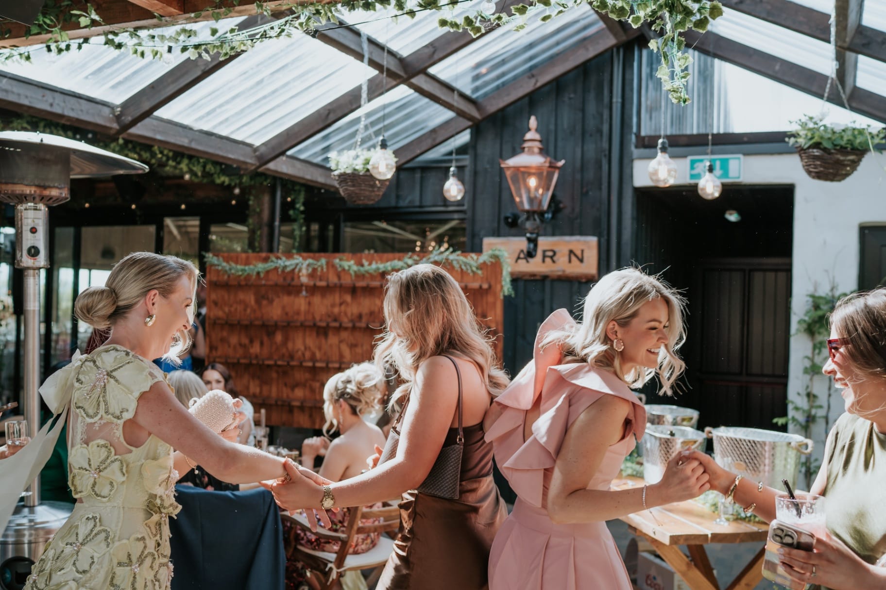 Wedding guests dancing in a line outside The Barn at Ballyness