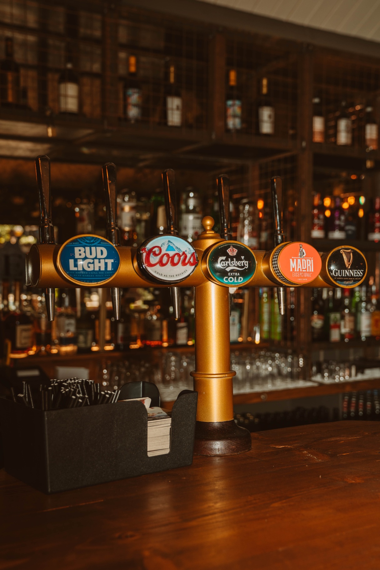 Brass beer taps at the Saloon bar — Bud Light, Coors, Carlsberg, Madrí and Guinness
