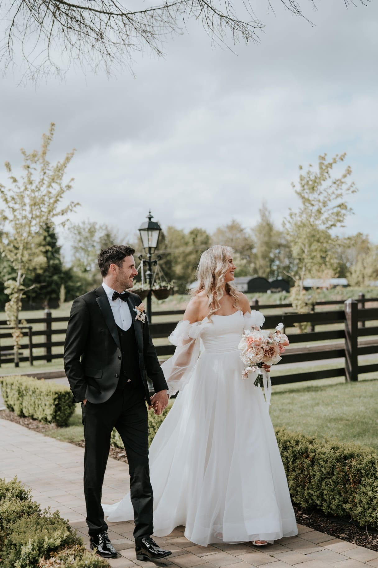 Bride and groom strolling beside the Ballyness lawns