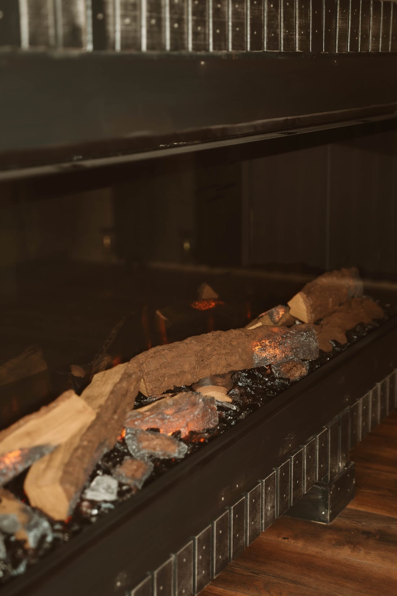 Treehouse Lookout close-up of the fireplace with glowing embers and black metal surround