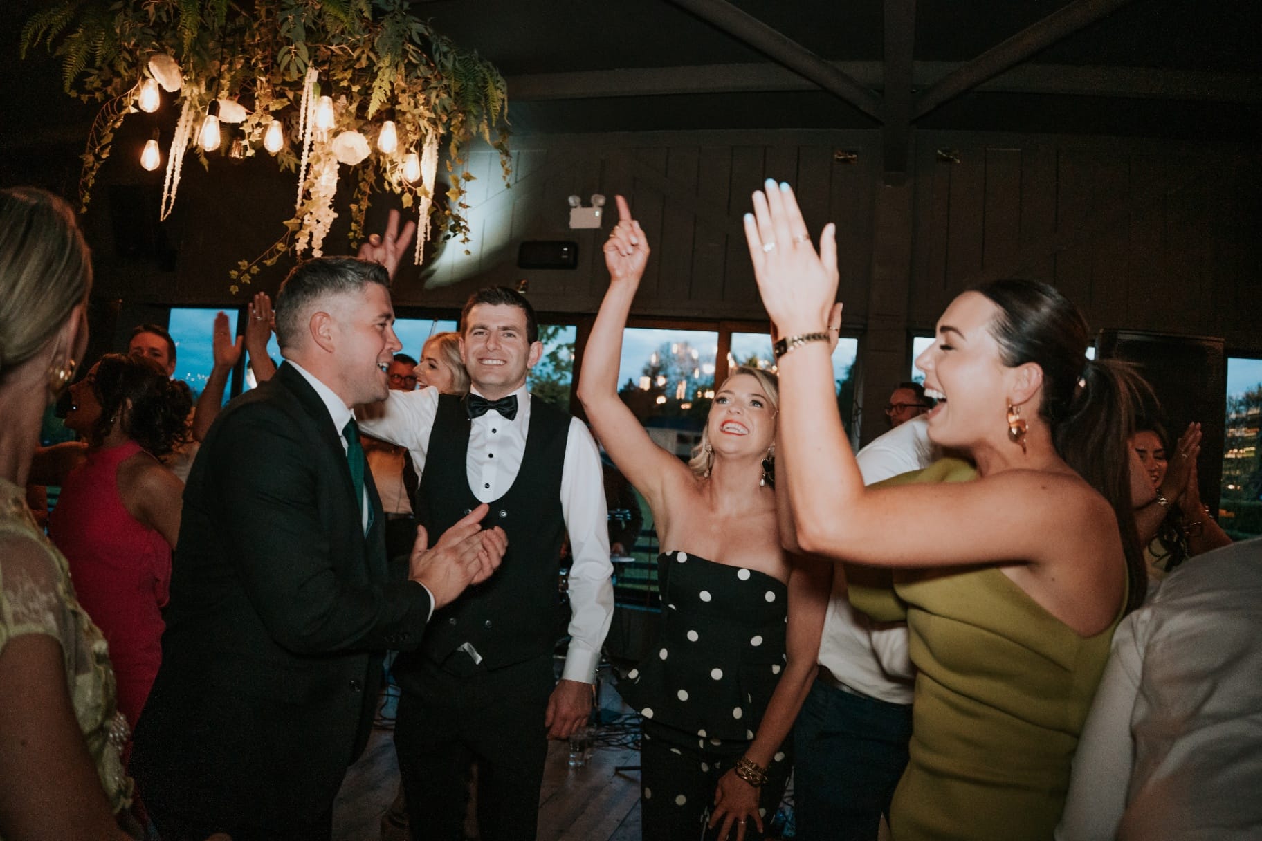 Guests cheering and dancing with hands in the air on the dance floor