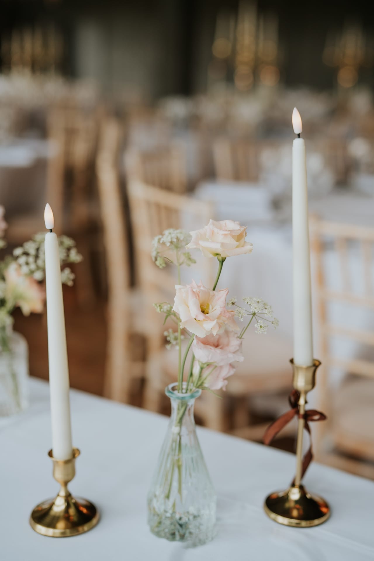 Bud vase centrepiece with taper candles and ribbon detail