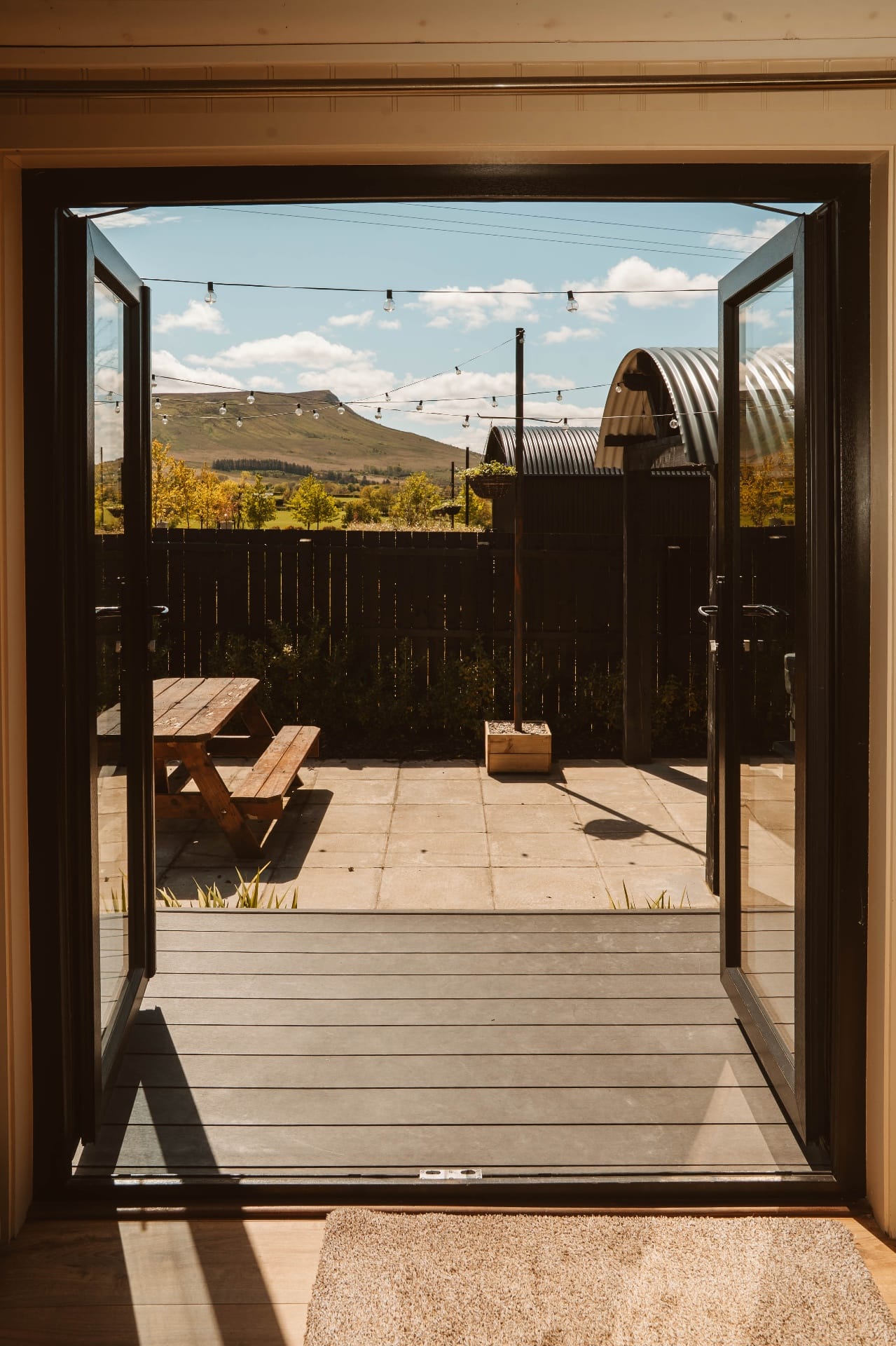 Open Shepherd's Hut doors framing the patio and Ballyness mountain view