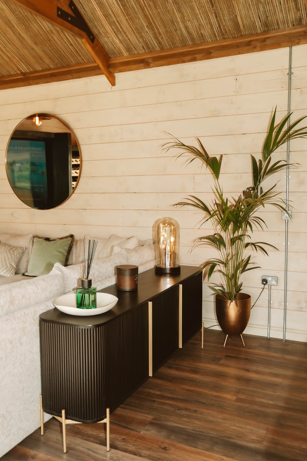Treehouse Lookout black sideboard with decorative lighting and tall bronze planter