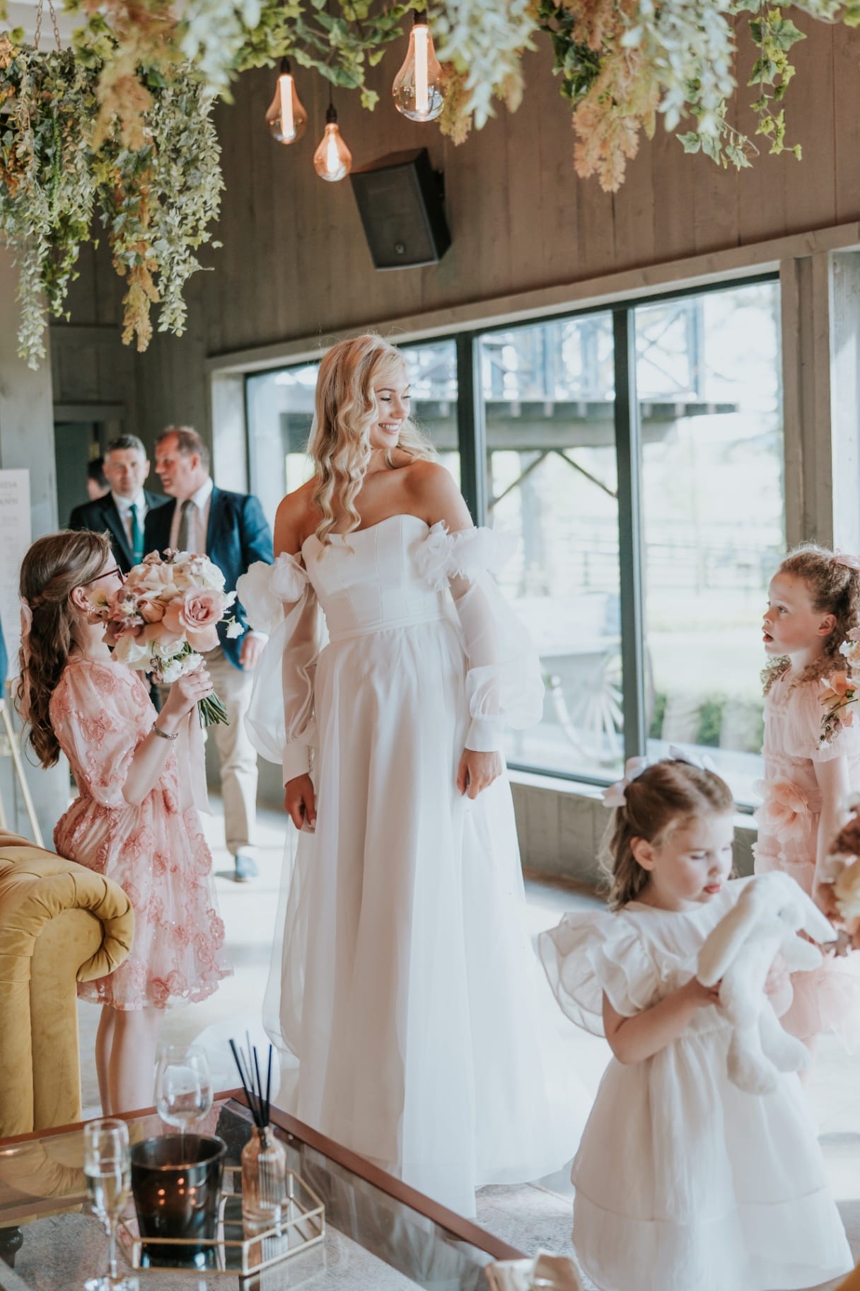 Bride with flower girls and bridesmaid in the foliage-draped reception room