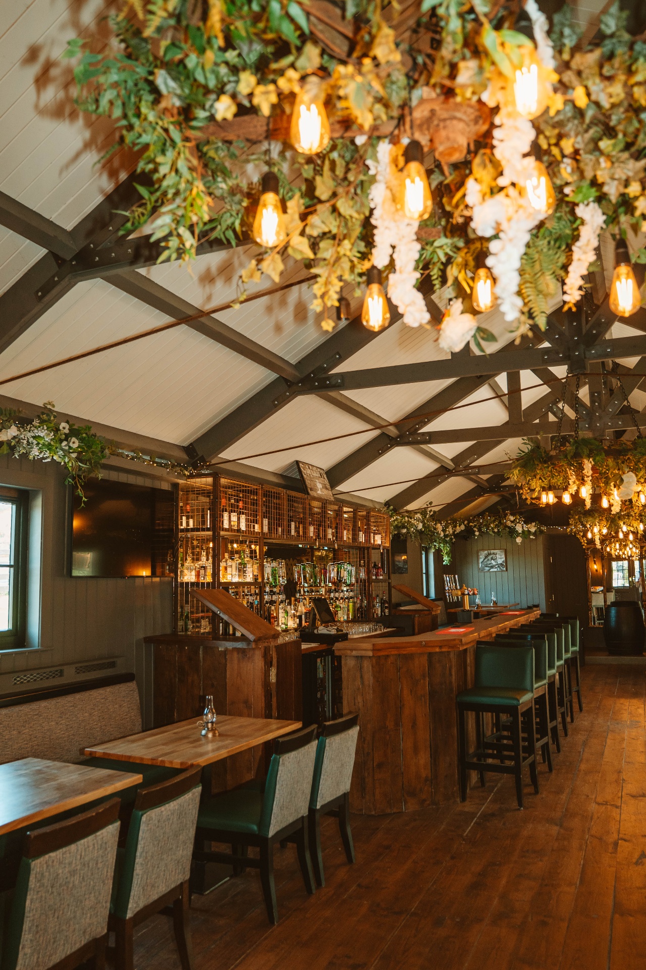 The bar at The Grange beneath floral chandeliers