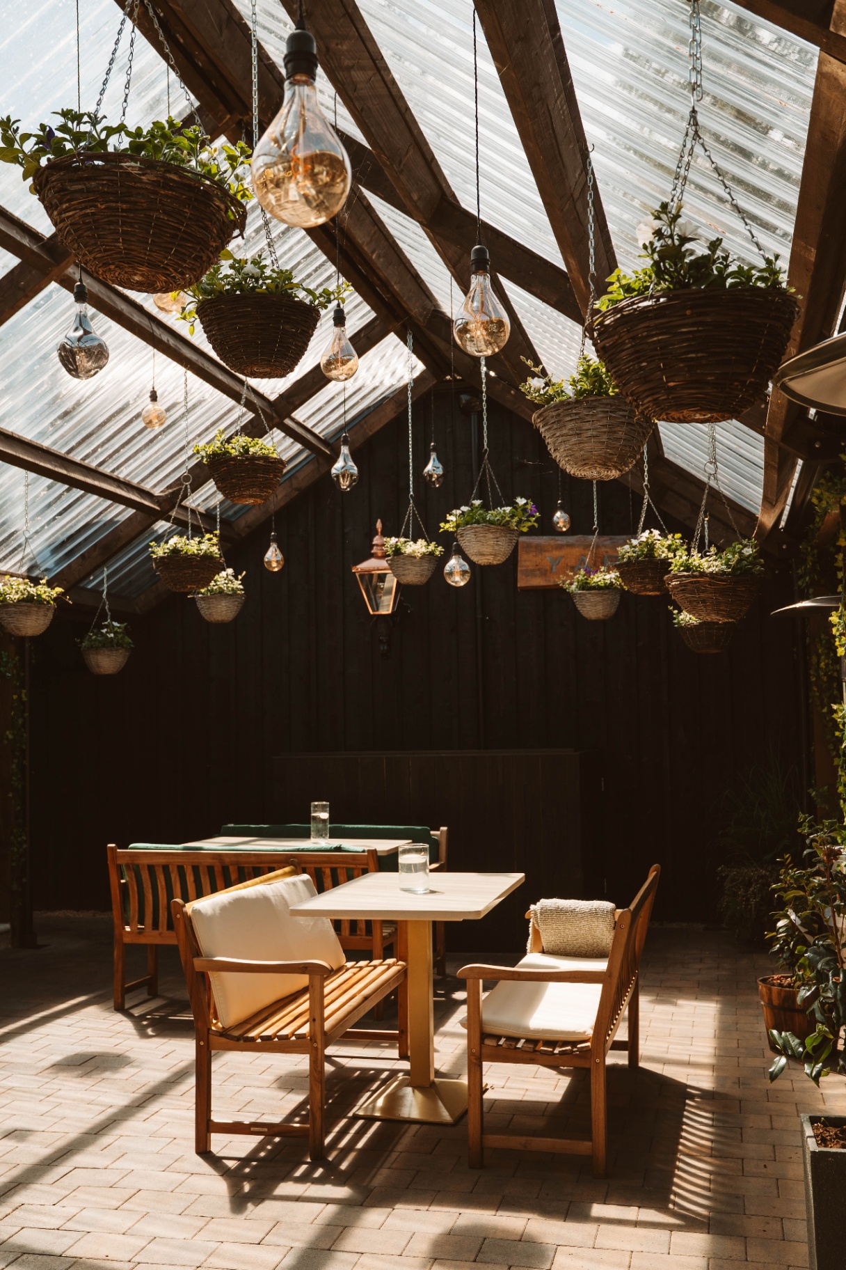 Wooden benches beneath a canopy of hanging baskets in the Courtyard