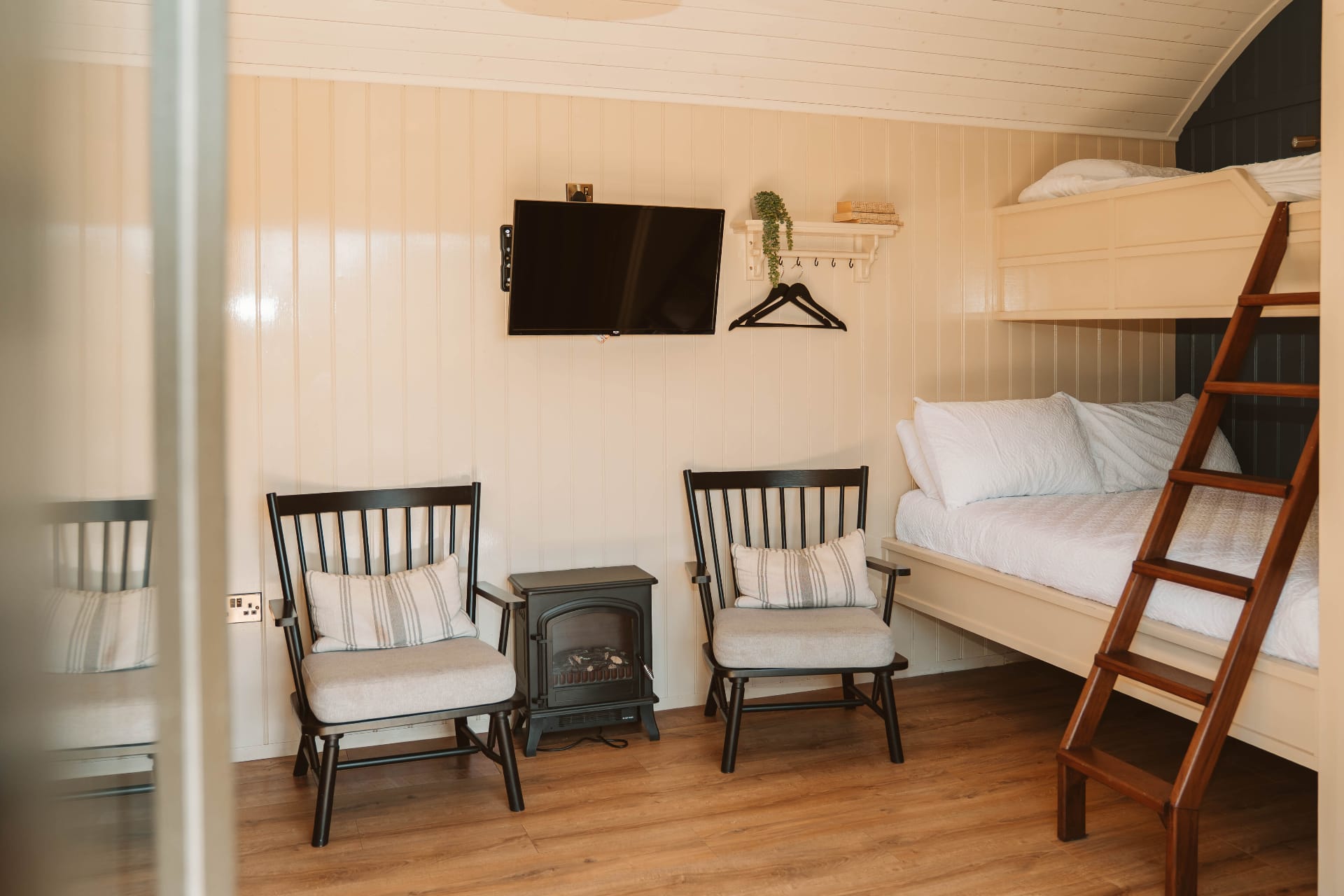 Shepherd's Hut living area with bunk beds, log burner and TV