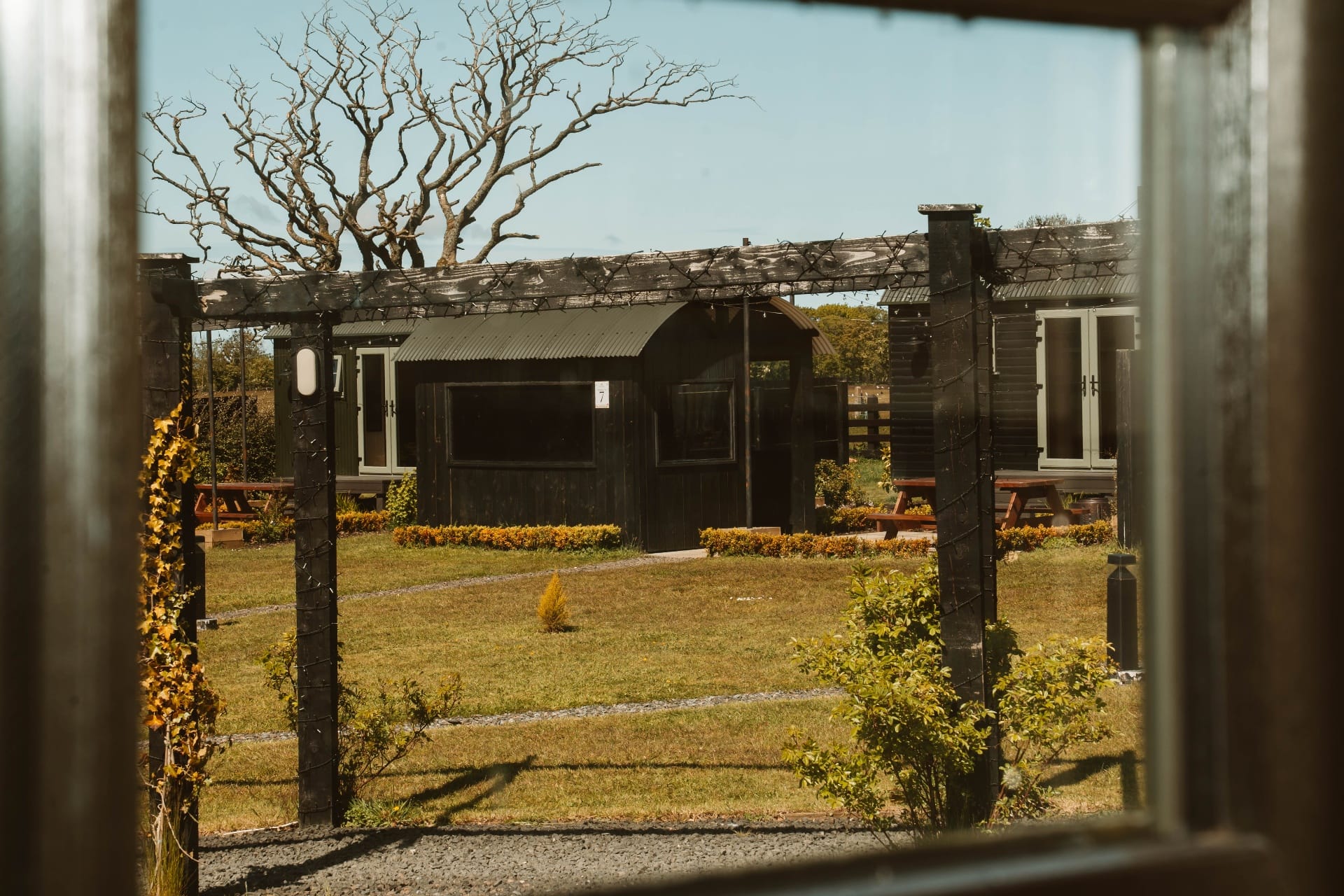 View from the Shepherd's Hut across the pergola to the resort lawn