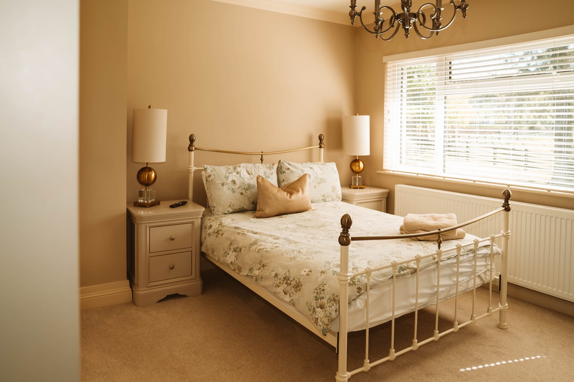 Farmhouse bedroom with ivory metal bed and floral linens