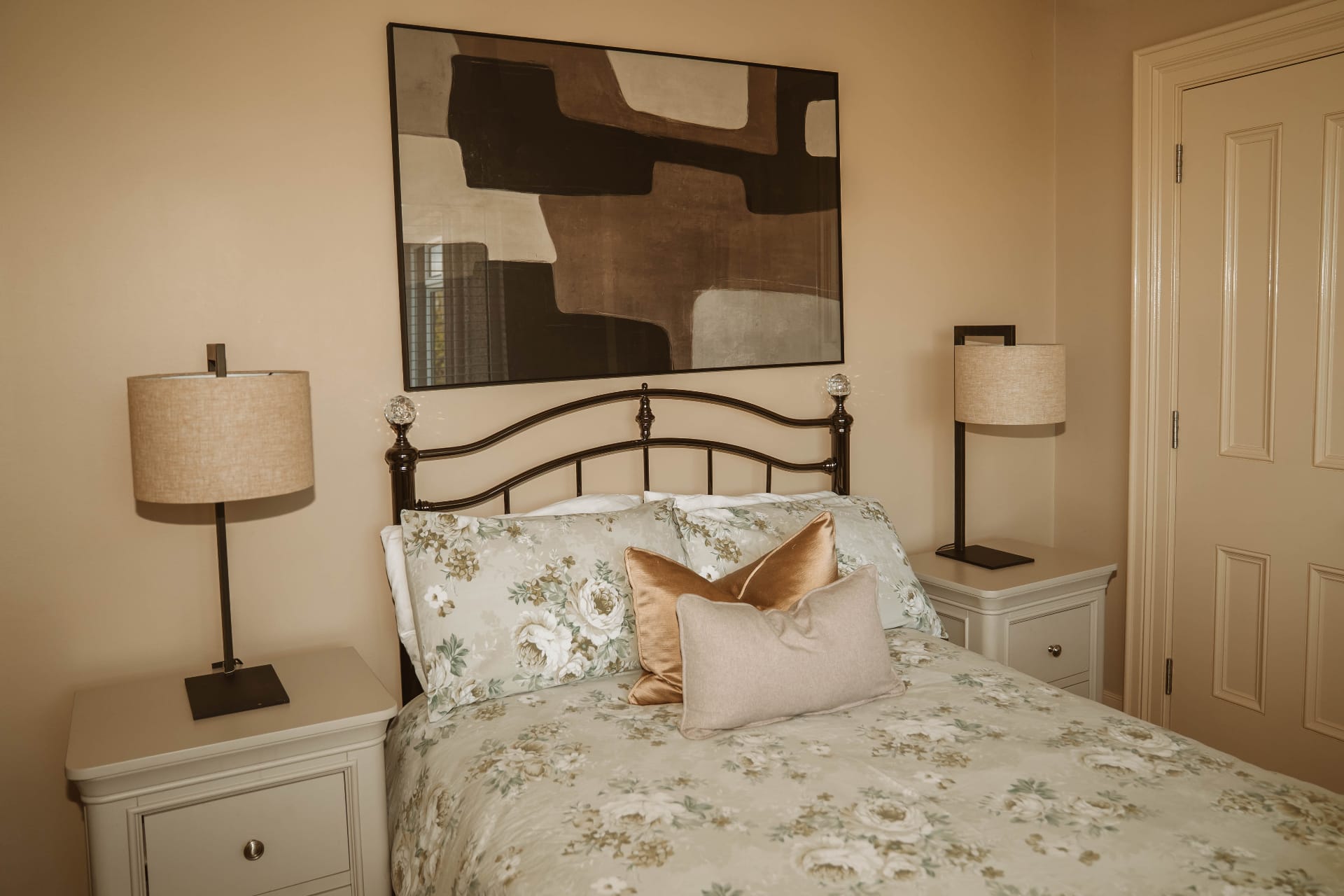 Farmhouse bedroom with floral bedding and twin bedside lamps