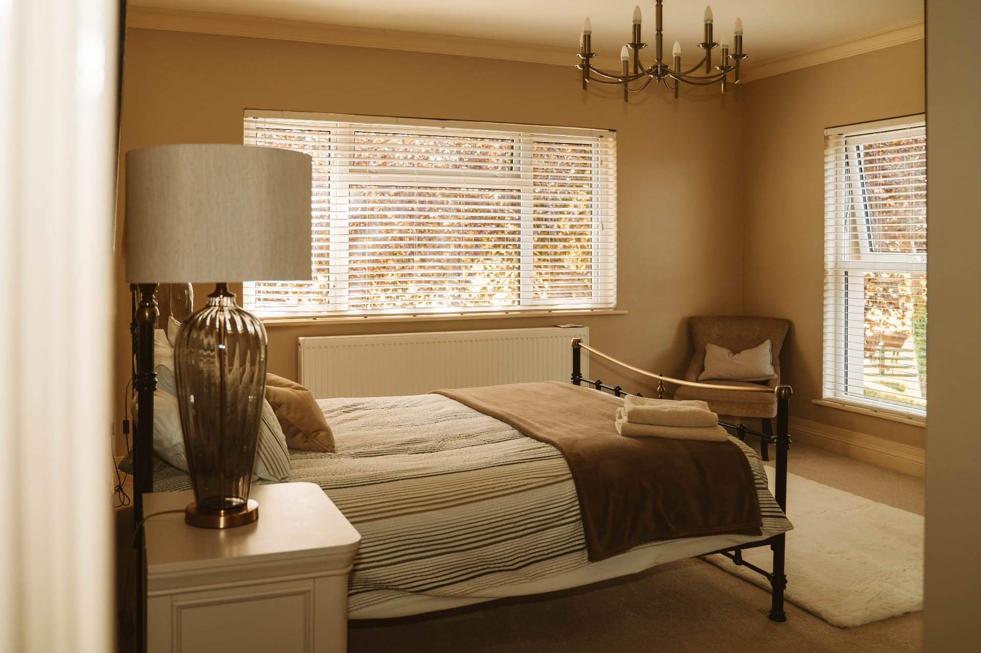 Farmhouse bedroom with cast iron bed and chandelier