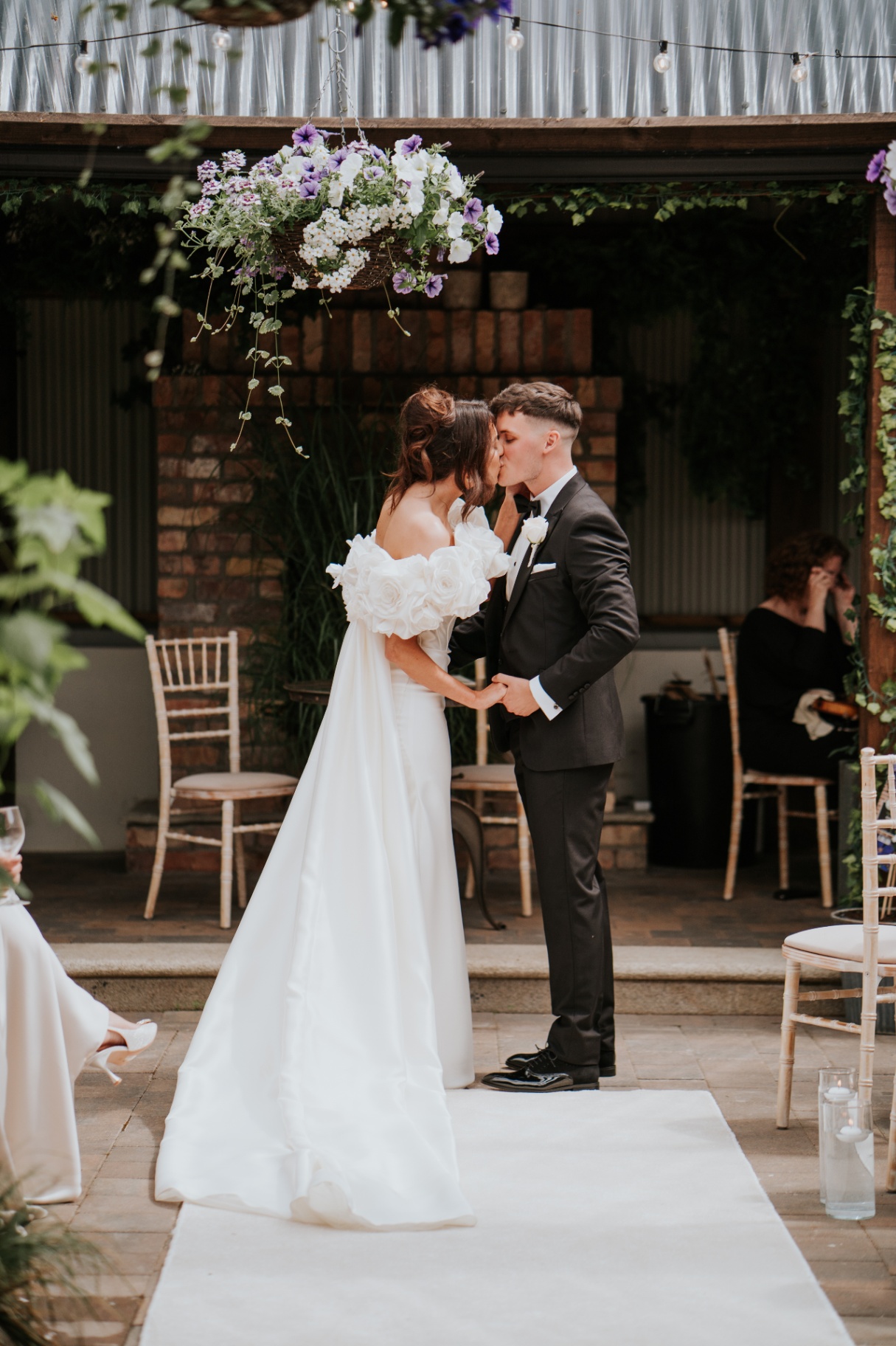 The couple's first kiss beneath the hanging florals
