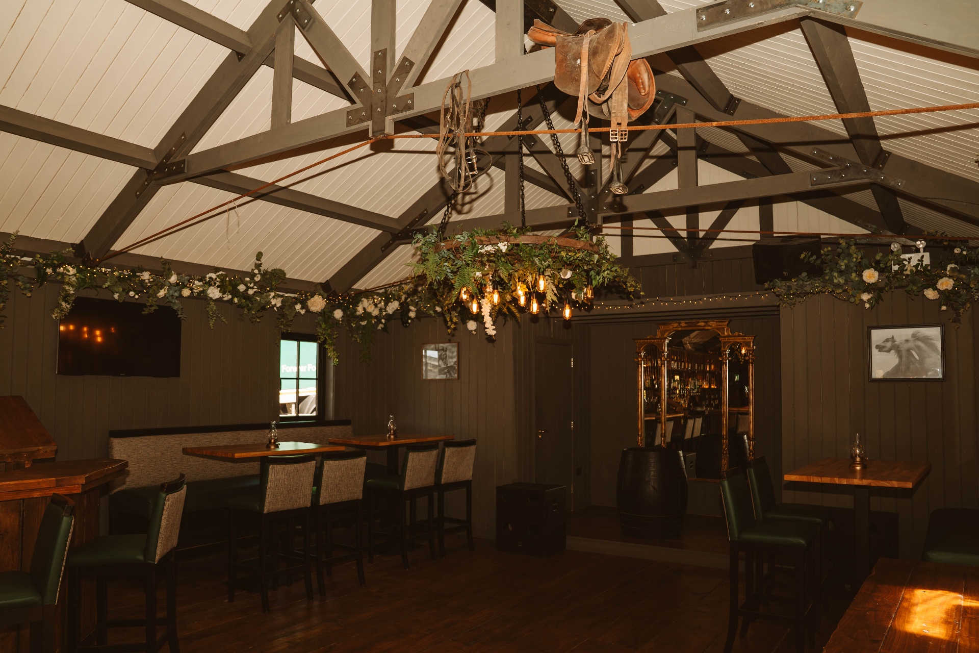 Interior of the Tack Room with floral chandelier, saddle centrepiece and booth seating