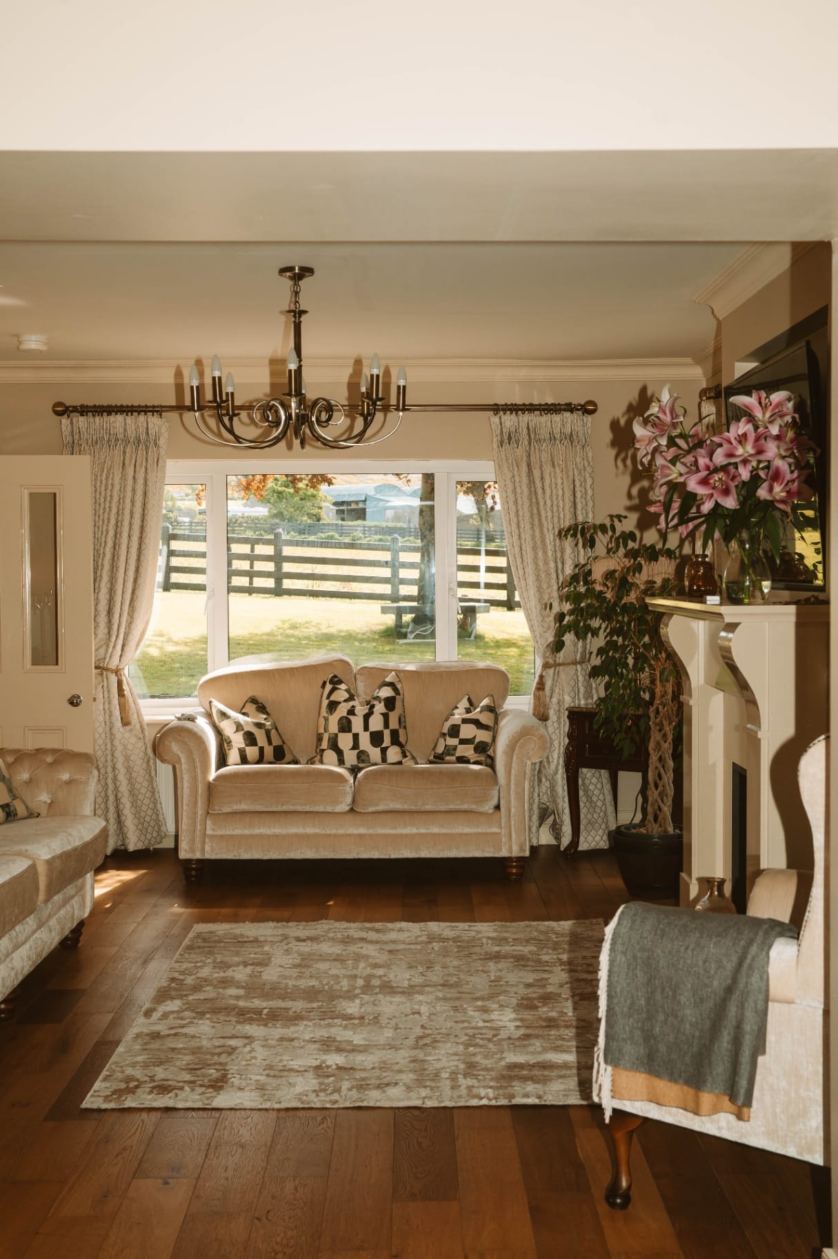 Farmhouse sitting room with chandelier and fireplace