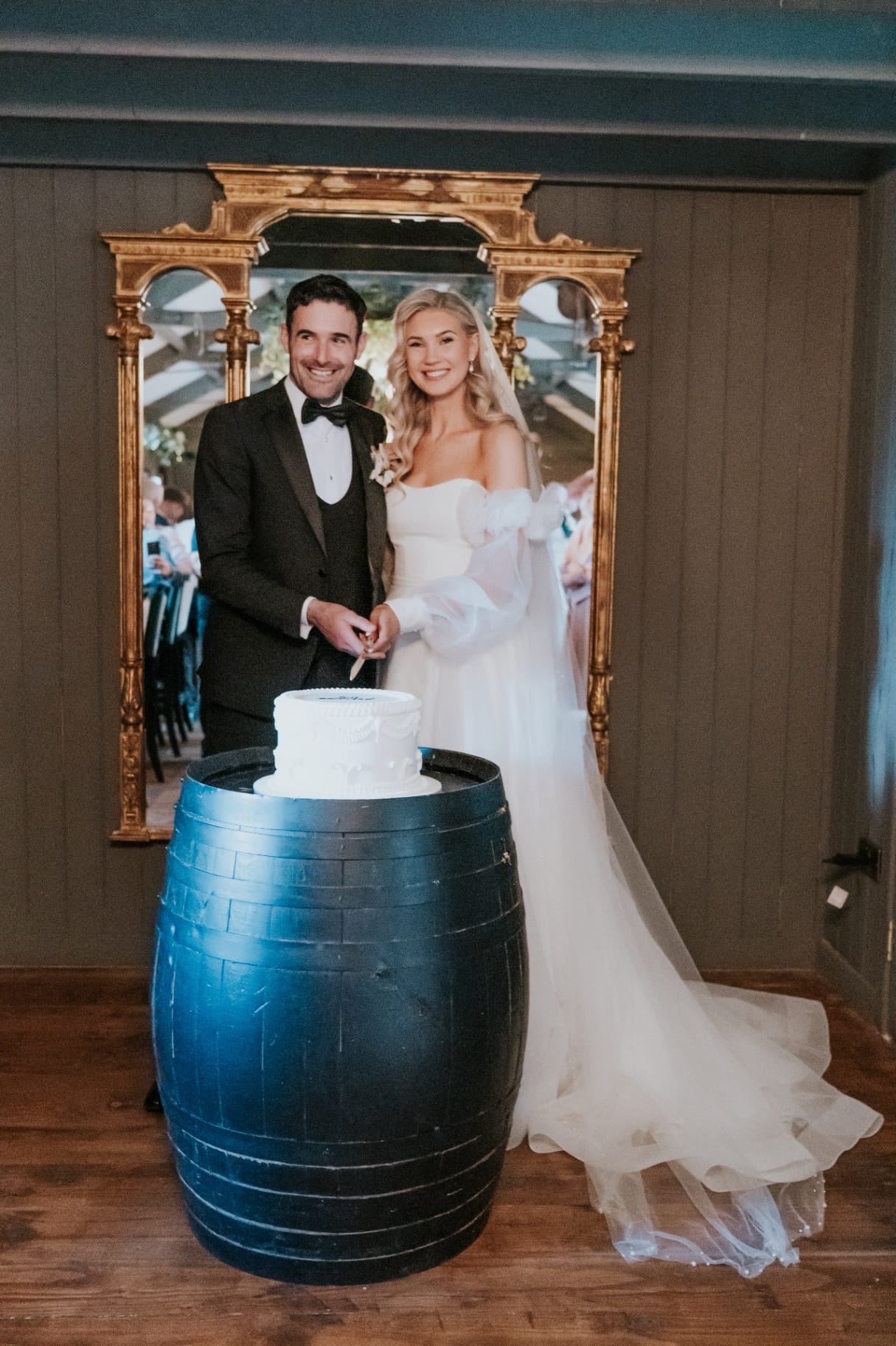 Bride and groom cutting the wedding cake on a whiskey barrel