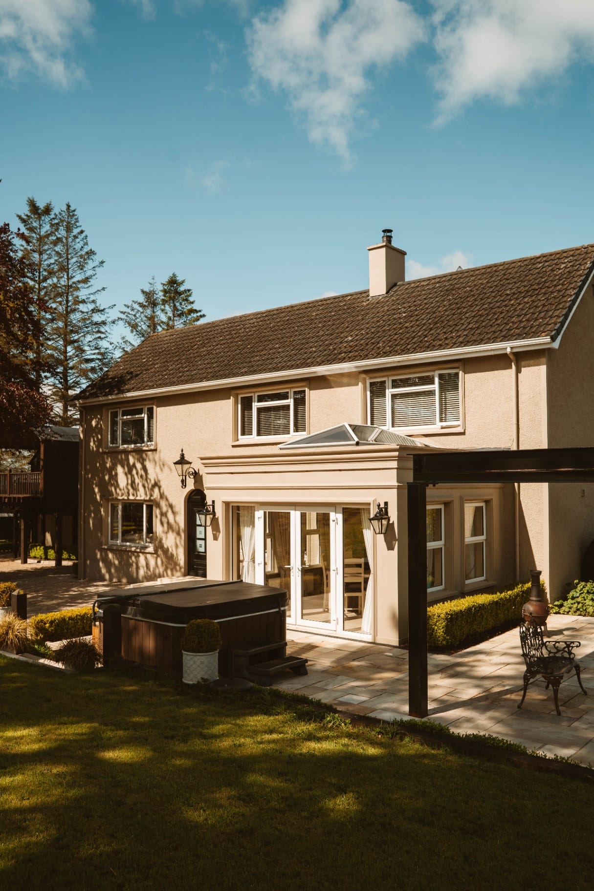 Farmhouse rear elevation with hot tub and pergola
