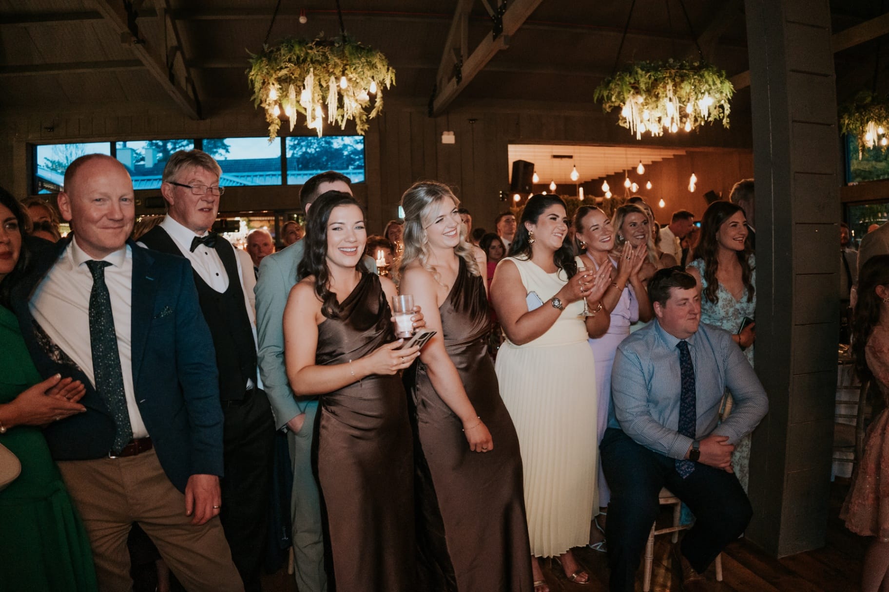 Wedding guests gathered and smiling during the evening reception