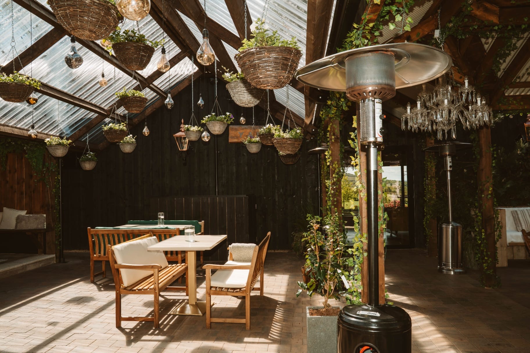 The Pergola dining space with chandeliers and hanging baskets
