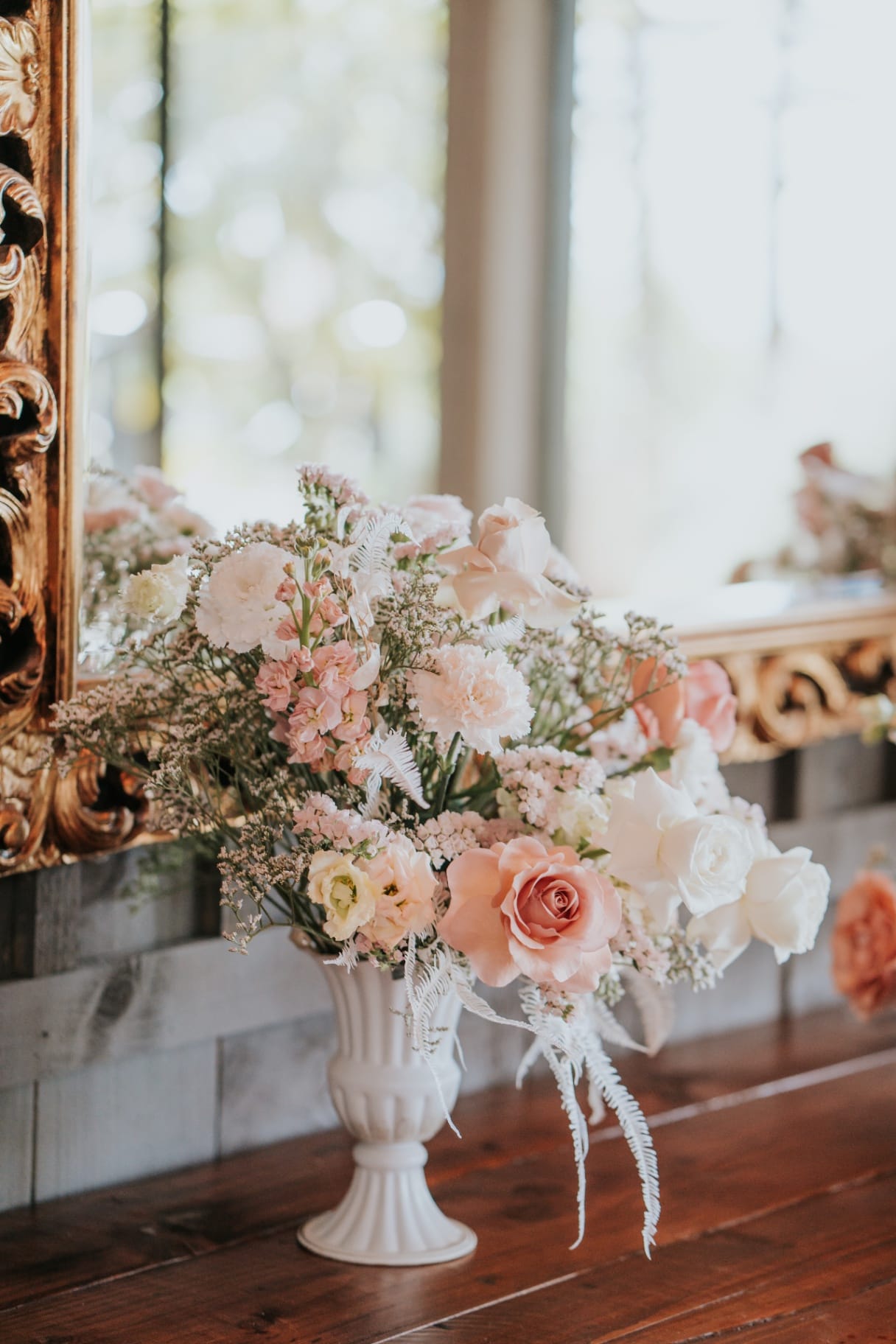 Close-up of blush and ivory wedding flowers arranged on the welcome table