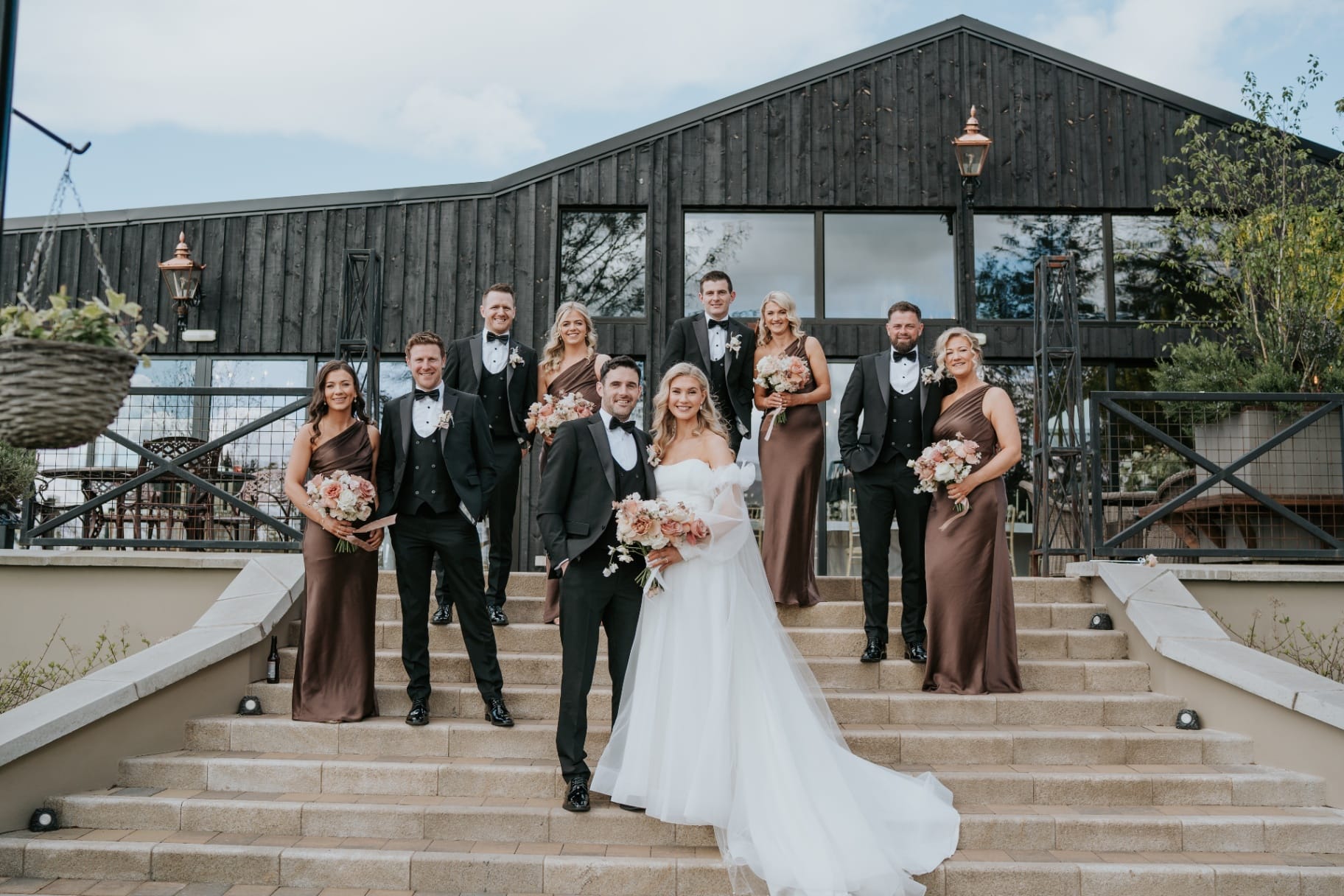 Bride, groom and wedding party posed on the Ballyness steps