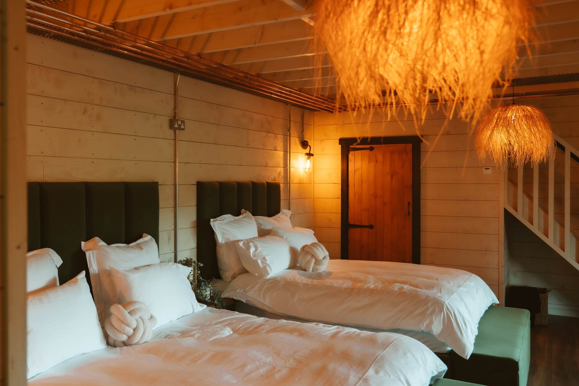 Treehouse Lookout twin bedroom with green headboards and mezzanine staircase
