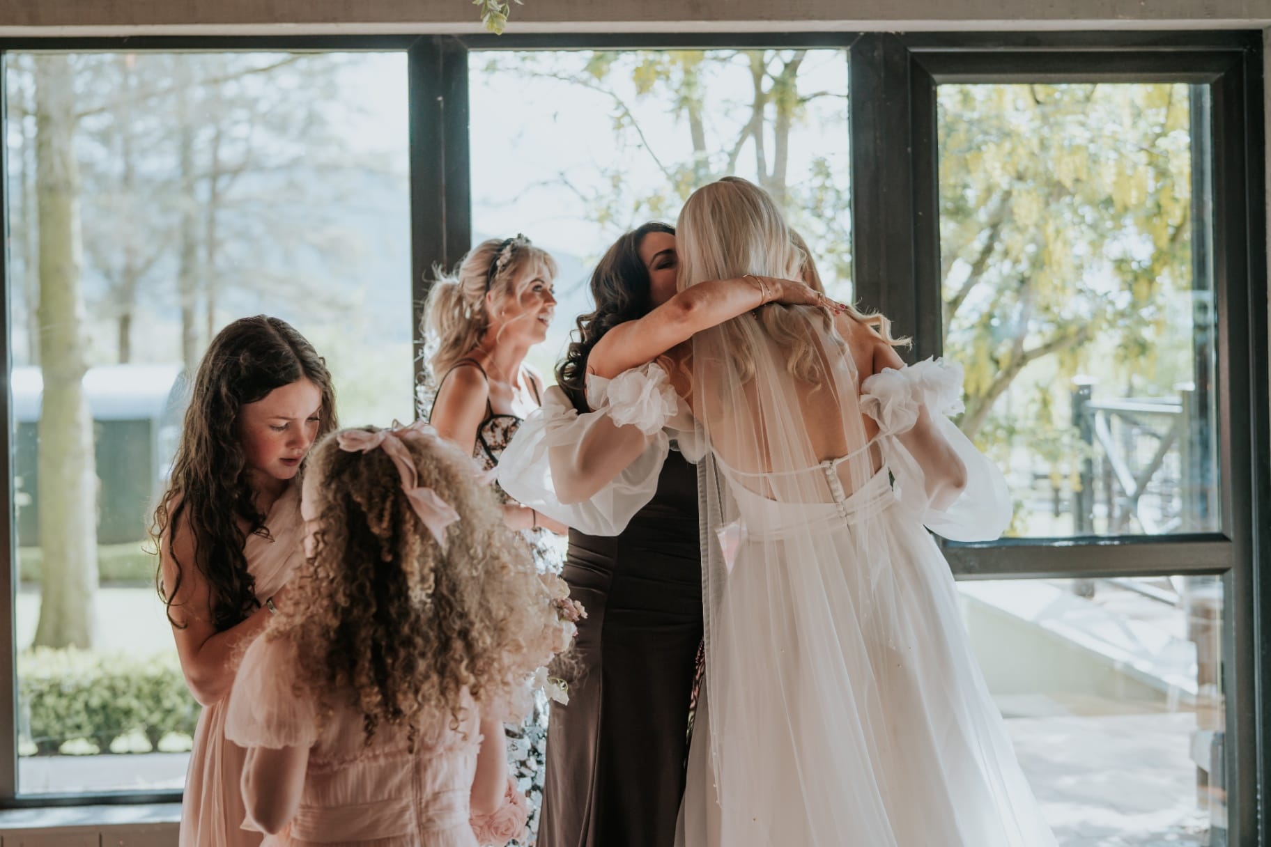 Bride hugging guests indoors before the reception