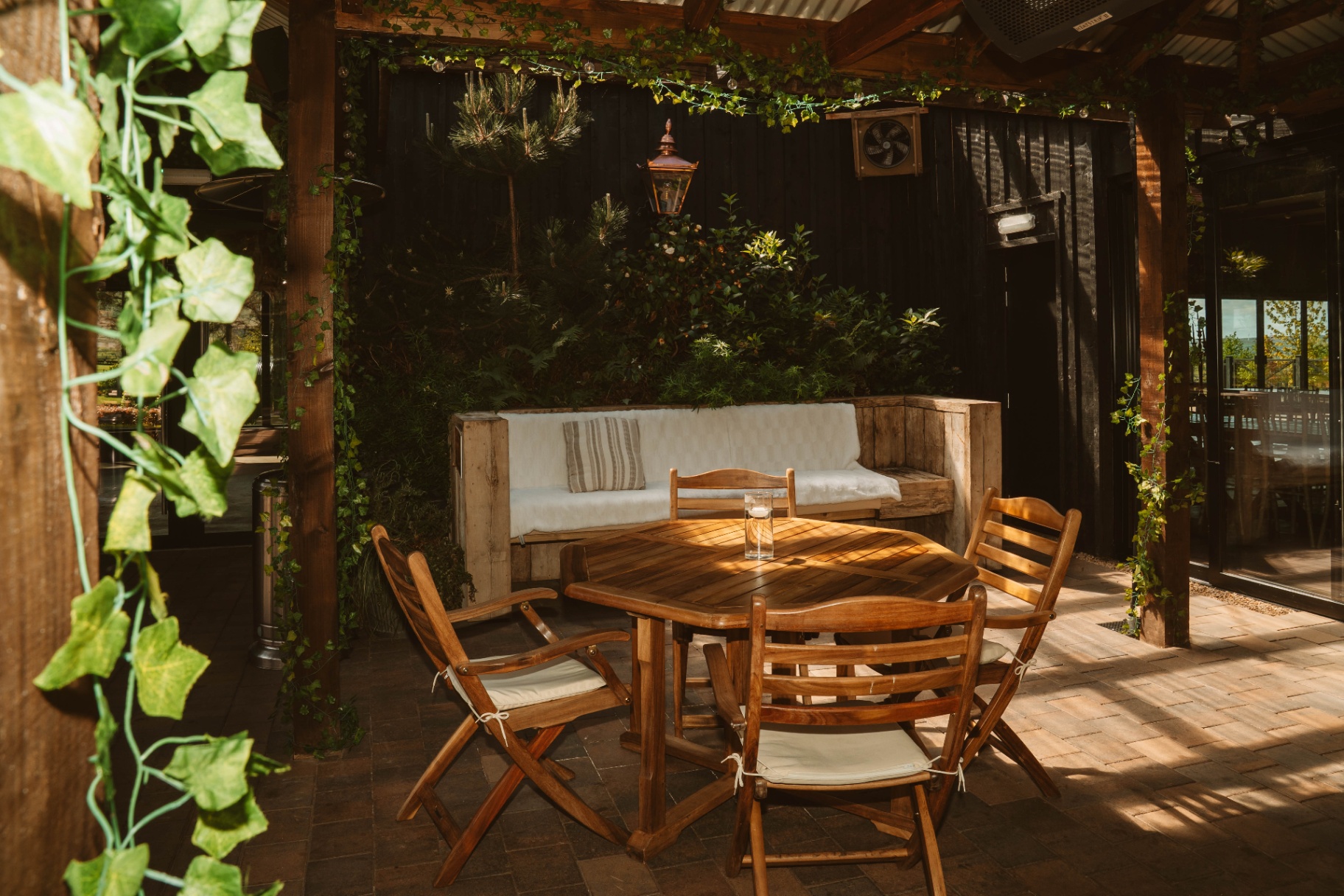 Quiet Courtyard seating nook with copper lantern and climbing greenery