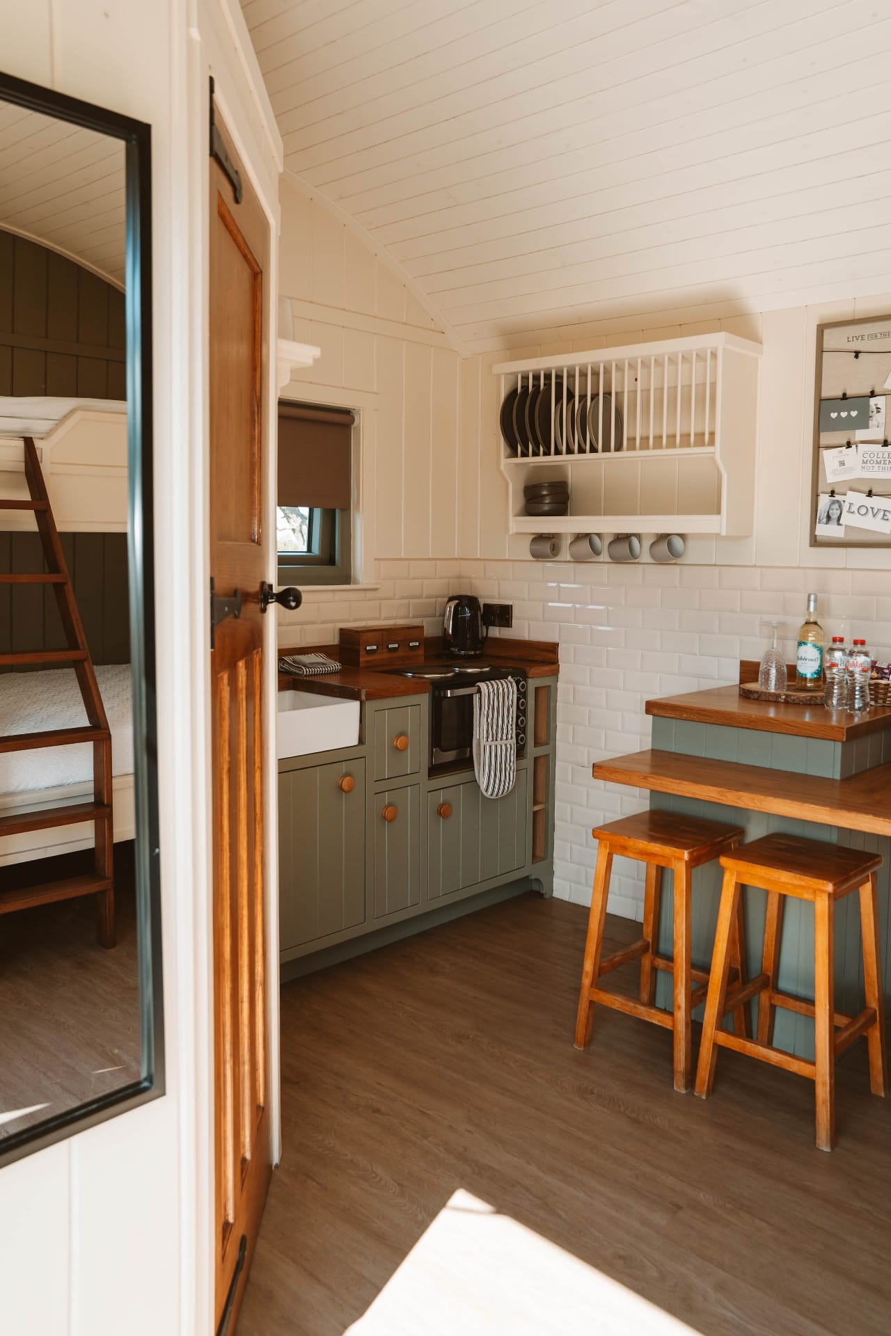 Shepherd's Hut kitchen with sage cabinetry and plate rack
