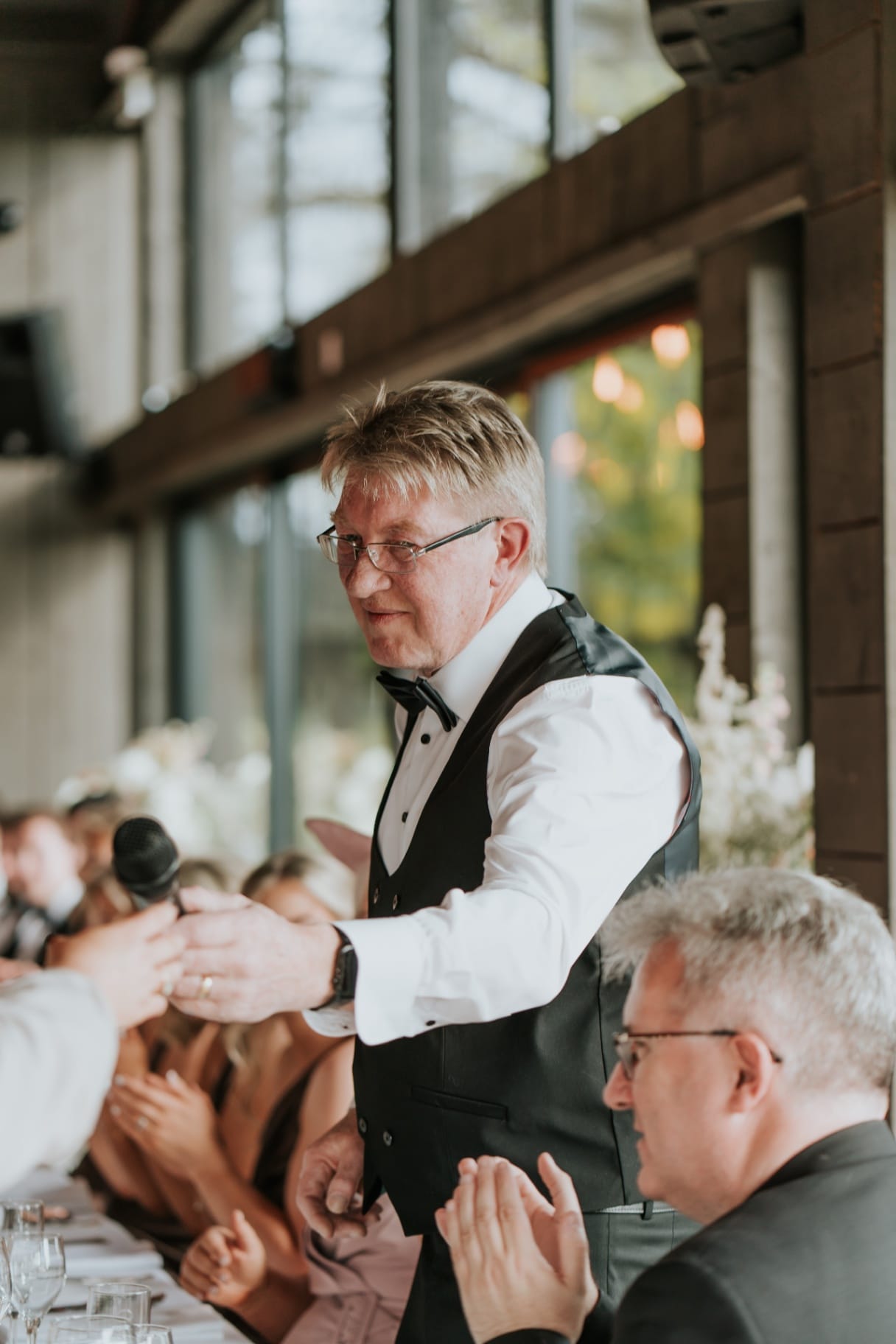 Father of the bride passing the microphone during heartfelt wedding speeches