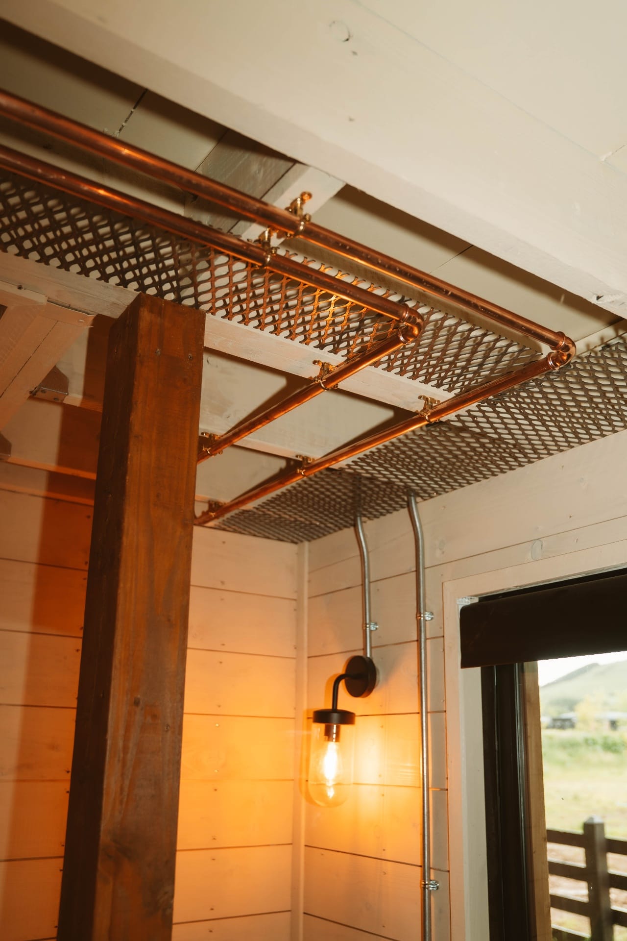 Treehouse Lookout copper pipe canopy and warm timber interior