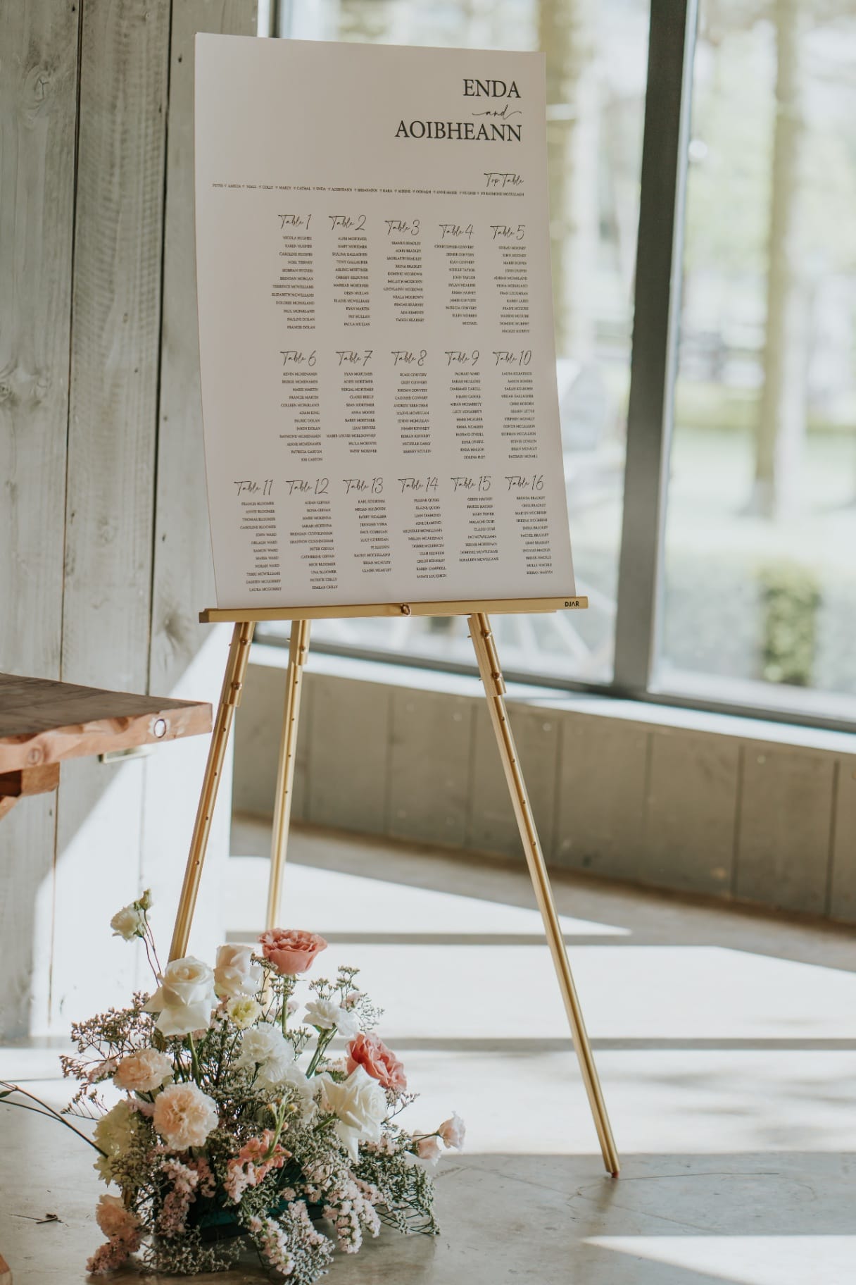 Wedding seating plan on an easel with florals in The Barn