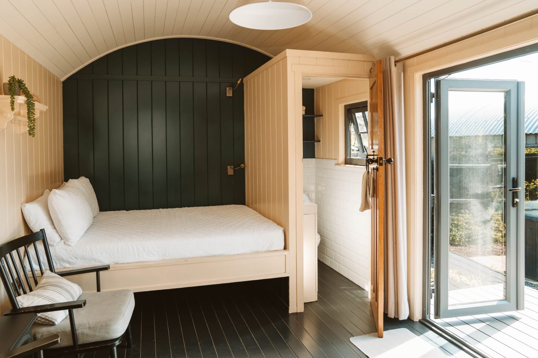 Shepherd's Hut bedroom interior with open doors to the deck