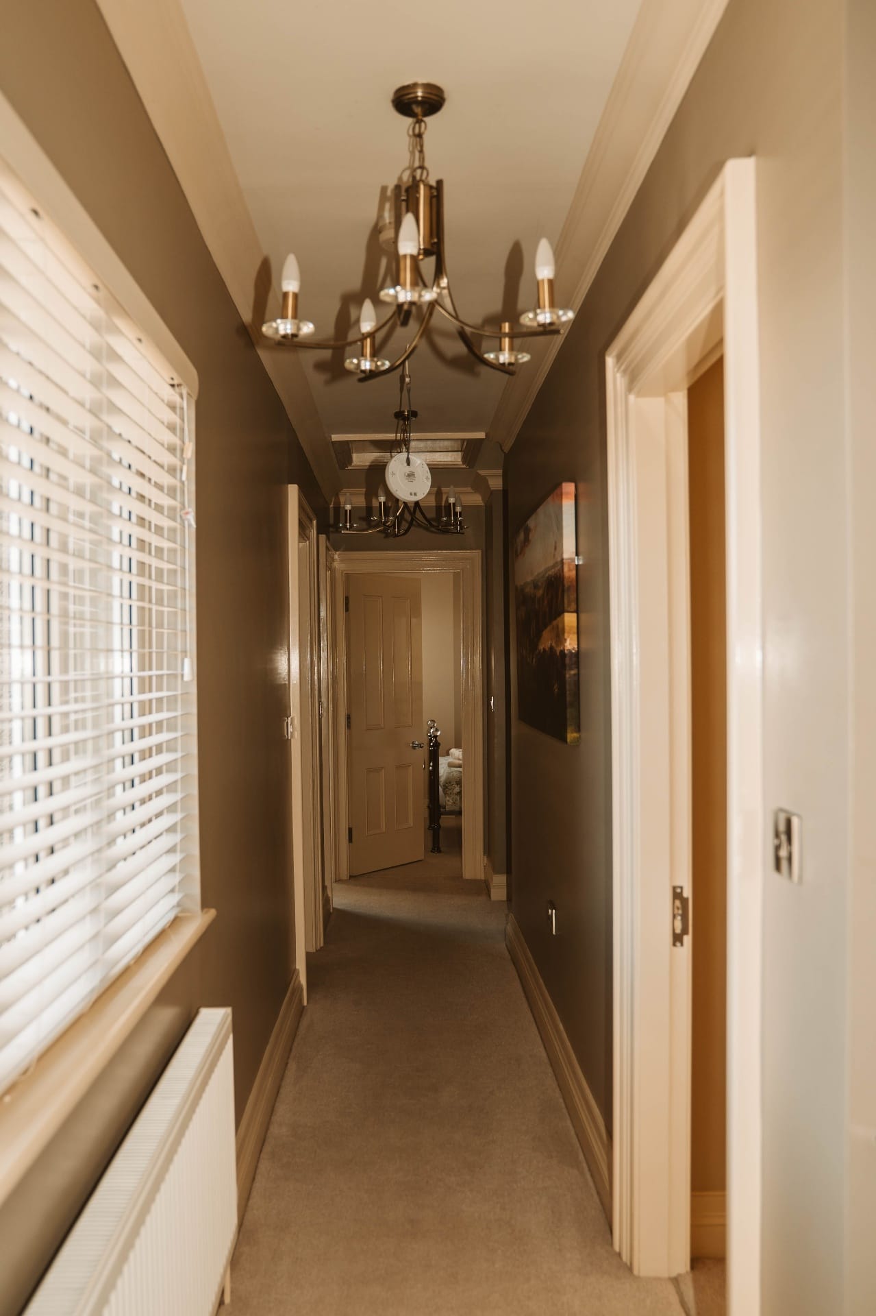 Farmhouse hallway with chandeliers and soft taupe walls