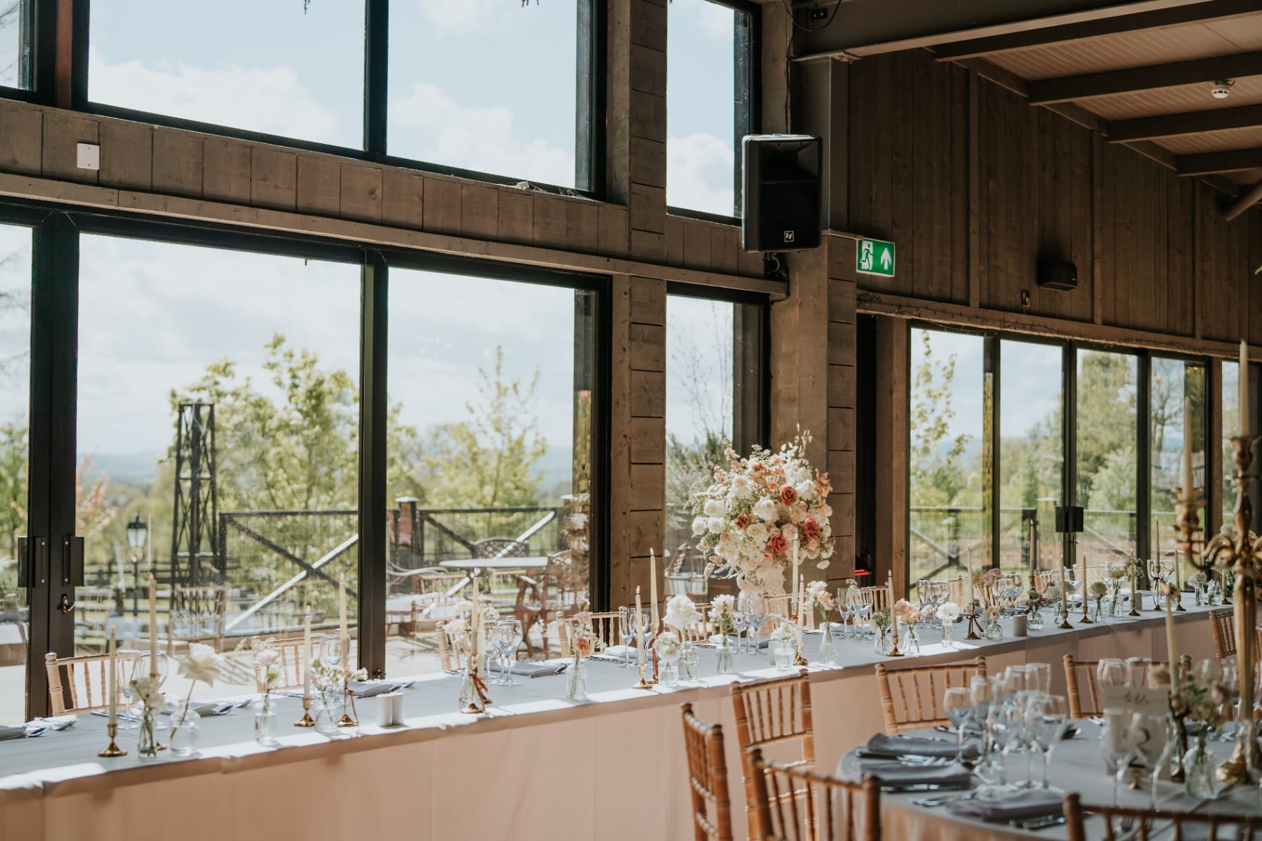 Wedding top table dressed with florals and candles overlooking the terrace