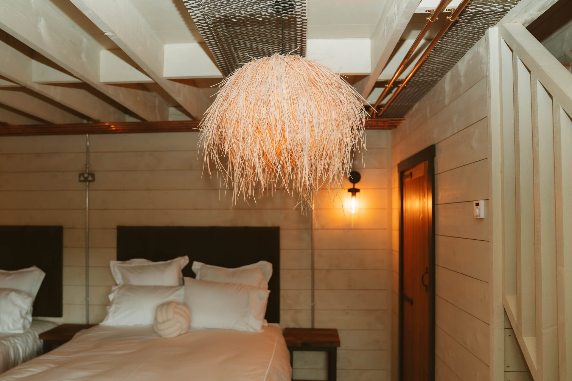 Treehouse Lookout bedroom view with raffia pendant and mezzanine staircase