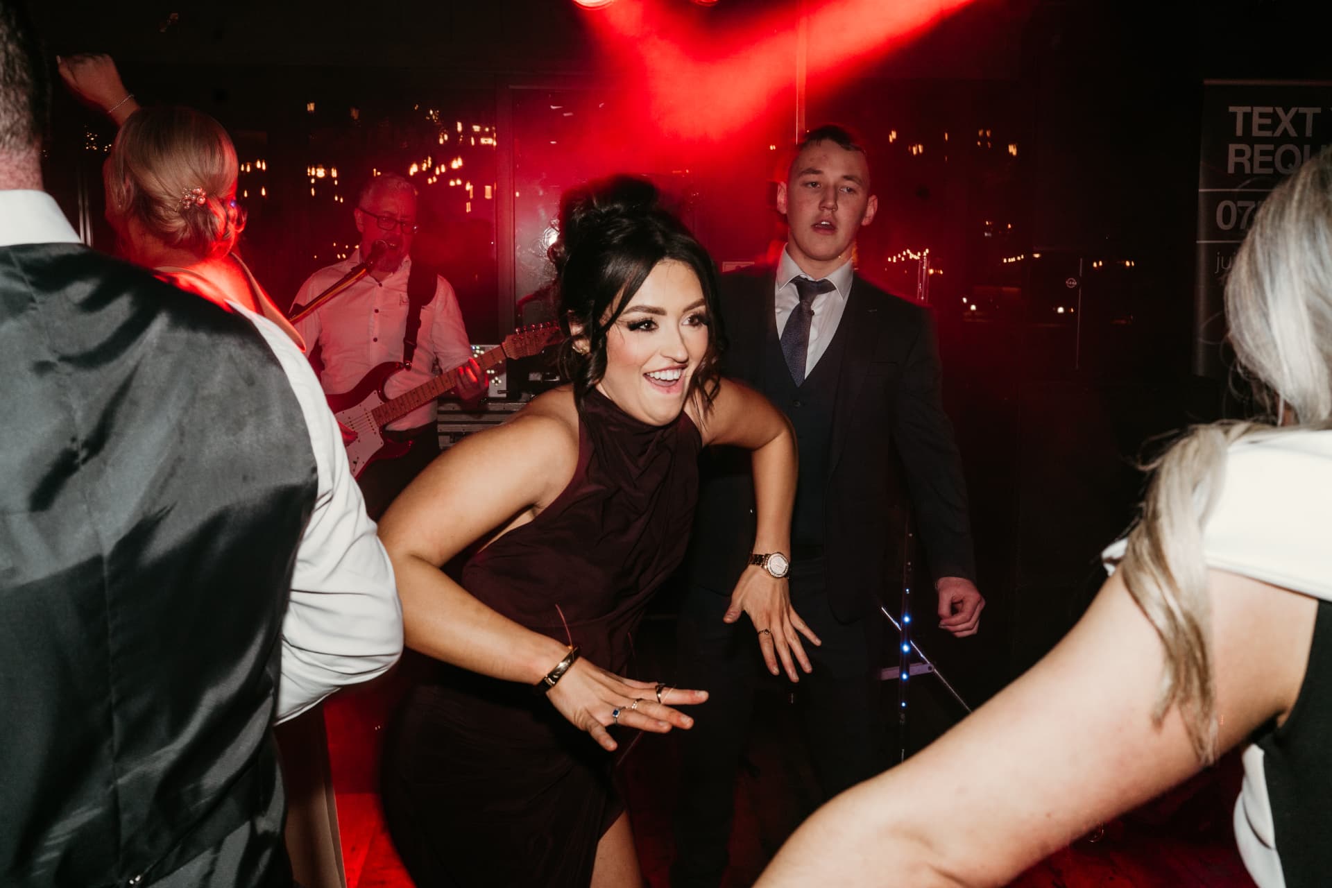 Guests dancing under red lights at a Ballyness party night
