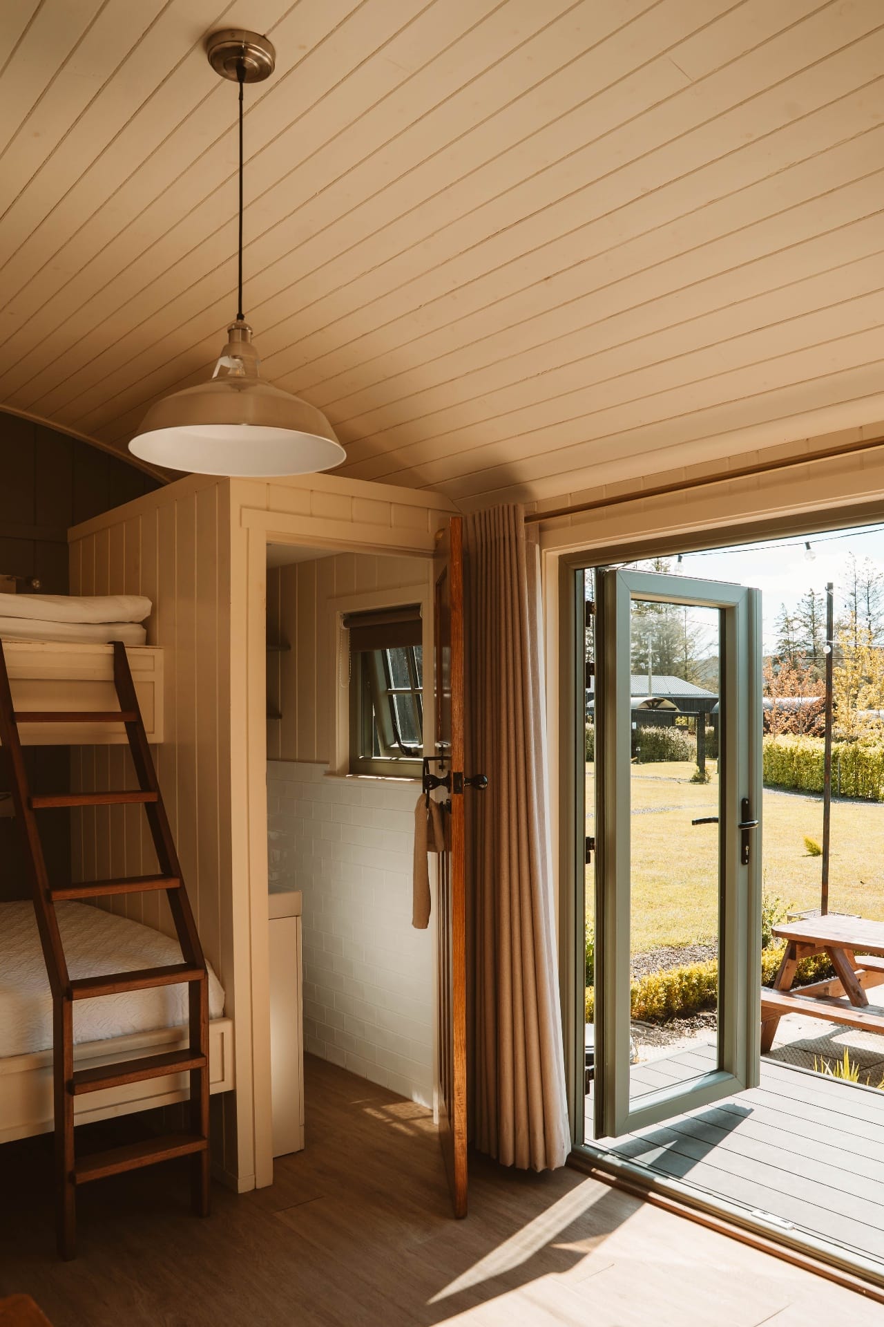 Shepherd's Hut interior looking out through open doors to the lawn