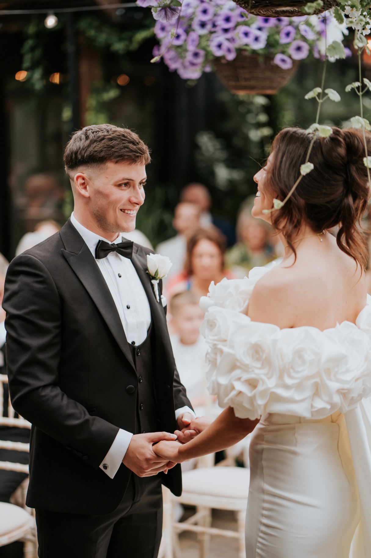 Bride and groom smiling at one another at the altar