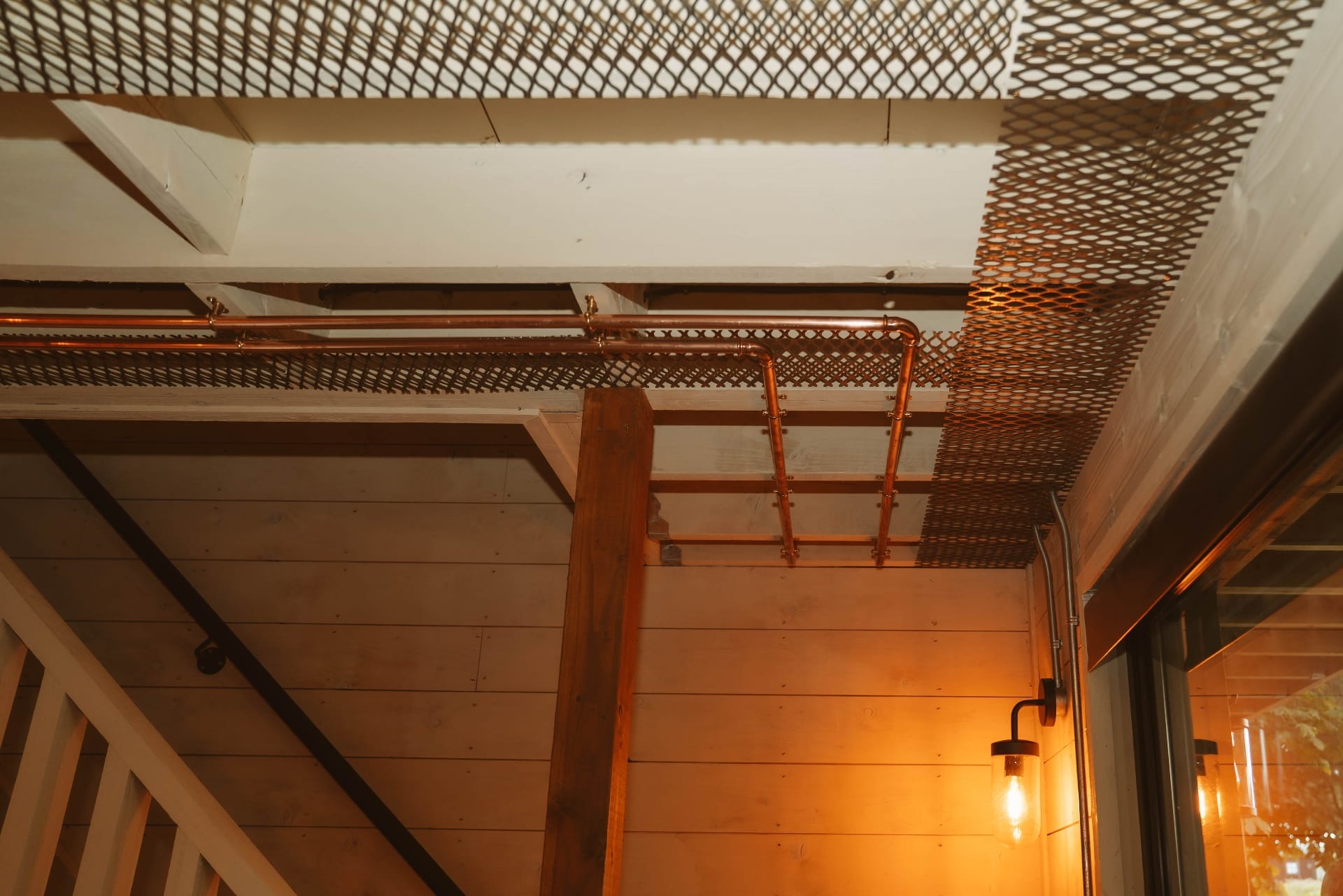 Treehouse Lookout copper pipework and mesh ceiling detail with industrial sconce