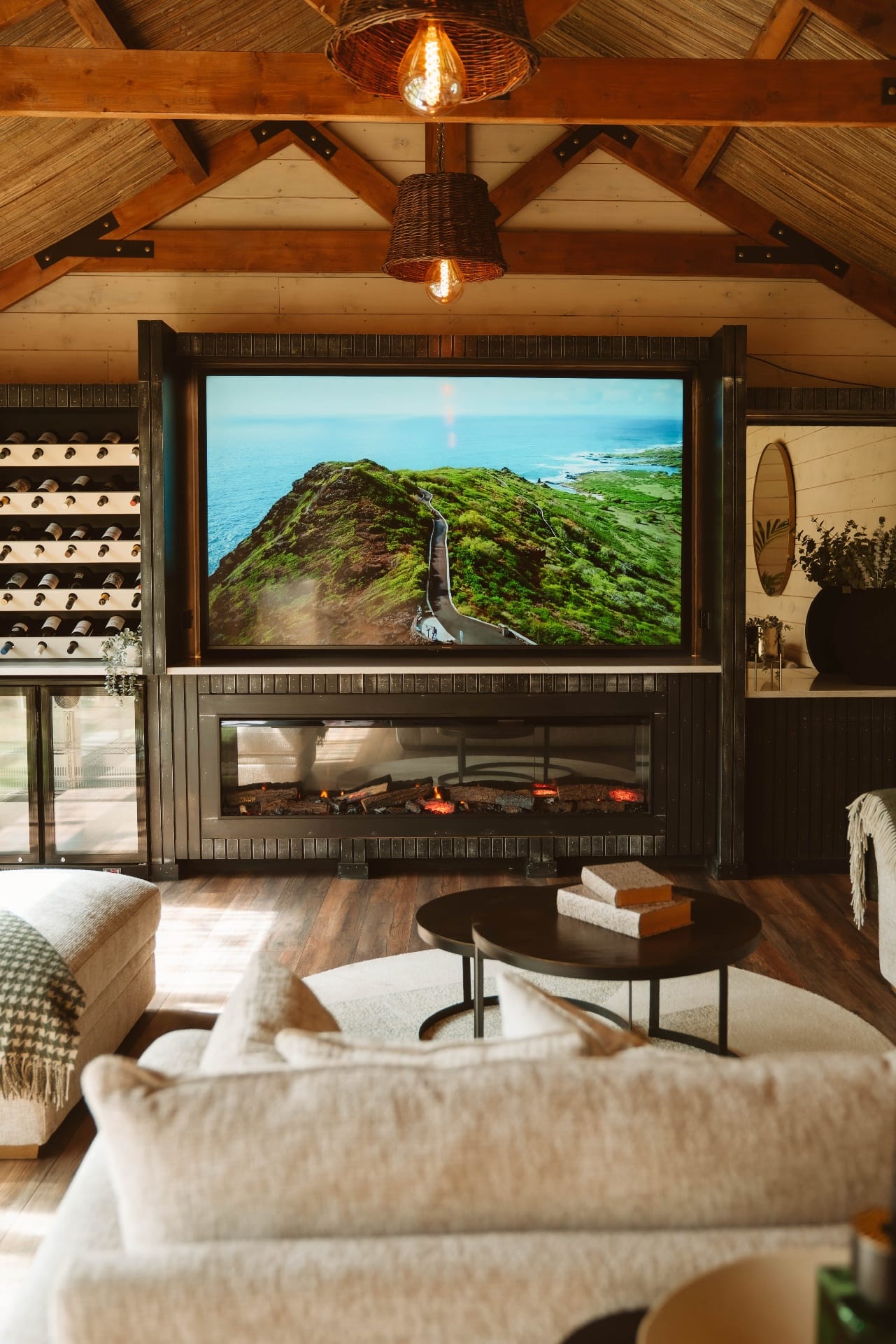 Treehouse Lookout media wall with fireplace, wine storage and coastal scene on screen