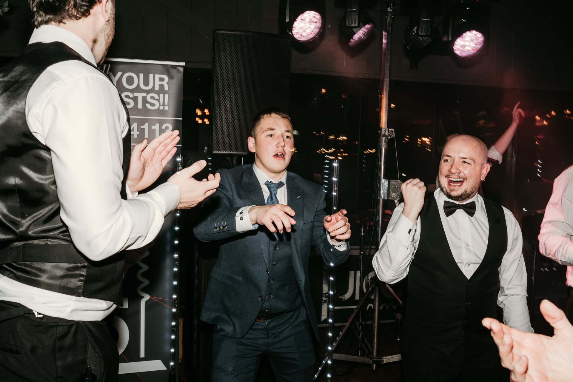 Groomsmen dancing by the DJ booth